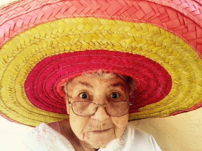 Alter Frau mit Sombrero schützt sich vor Hellem Hautkrebs