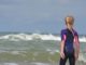 Mädchen am Meer in UV-Schutzkleidung